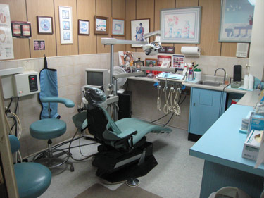 The image depicts a dental office with various equipment and chairs arranged within the space.