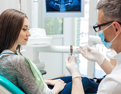 A woman receiving dental treatment with a professional dental hygienist administering care.